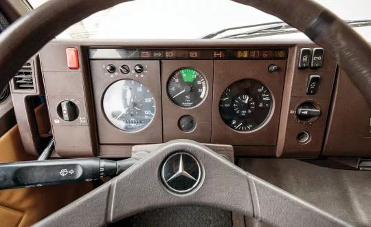 Το εσωτερικό ενός τράκτορα MercedesBenz 1317 από το 1989. Τυπικά χαρακτηριστικά είναι οι καφέ αποχρώσεις της δεκαετίας του 1980, ο περιορισμός των διακοπτών και οι ενδεικτικές λυχνίες στο πάνω άκρο του ταμπλό.